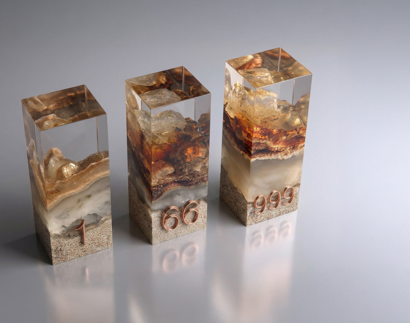 Three resin Legacy Pieces with unique numbers 1, 66 and 999 — UAE desert sand sealed in clear resin with gold leaf and copper engraving